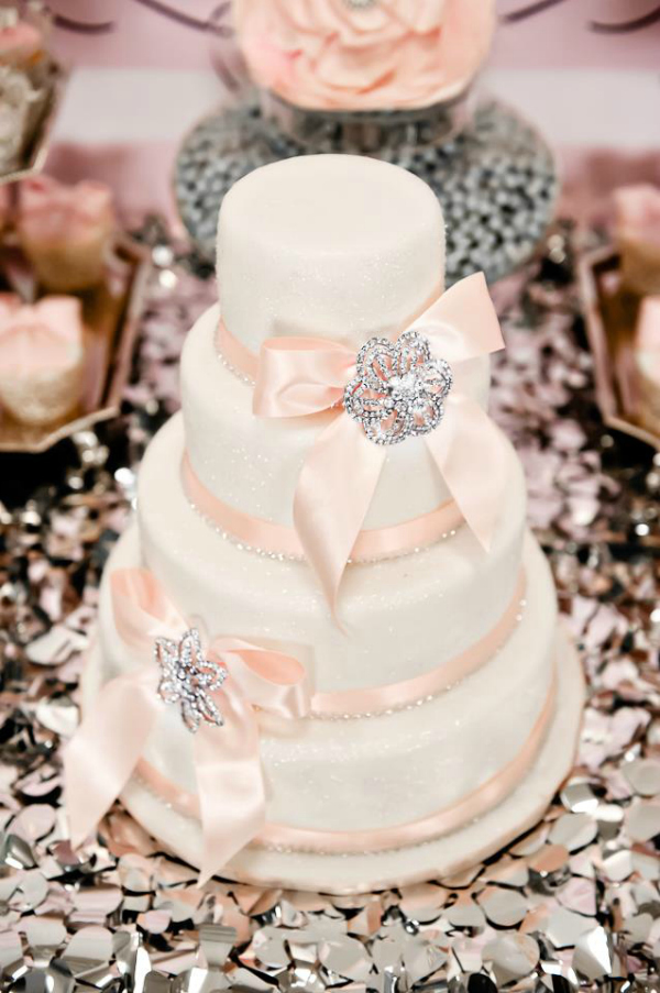 Pink and white wedding cake with ribbon and crystals