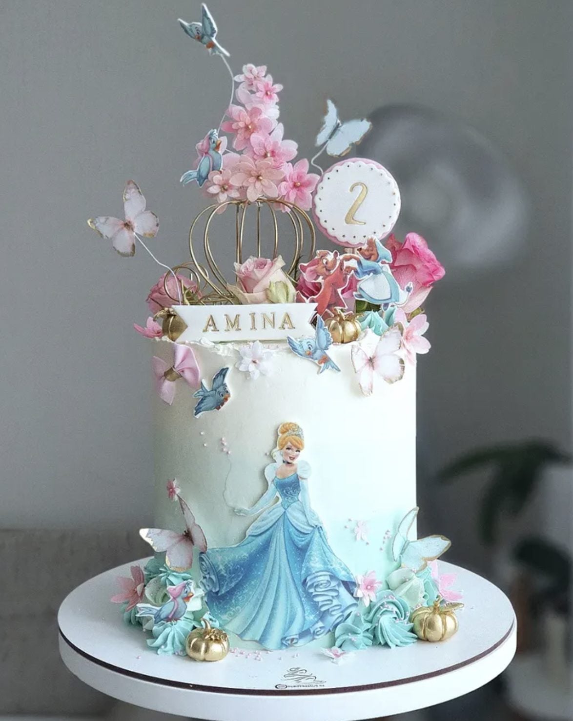 This blue Cinderella birthday cake is such a dreamy choice for a princess celebration. The soft blue cake, gold pumpkin accents, pink flowers, butterflies, and Cinderella character details make it feel magical without being too busy.
