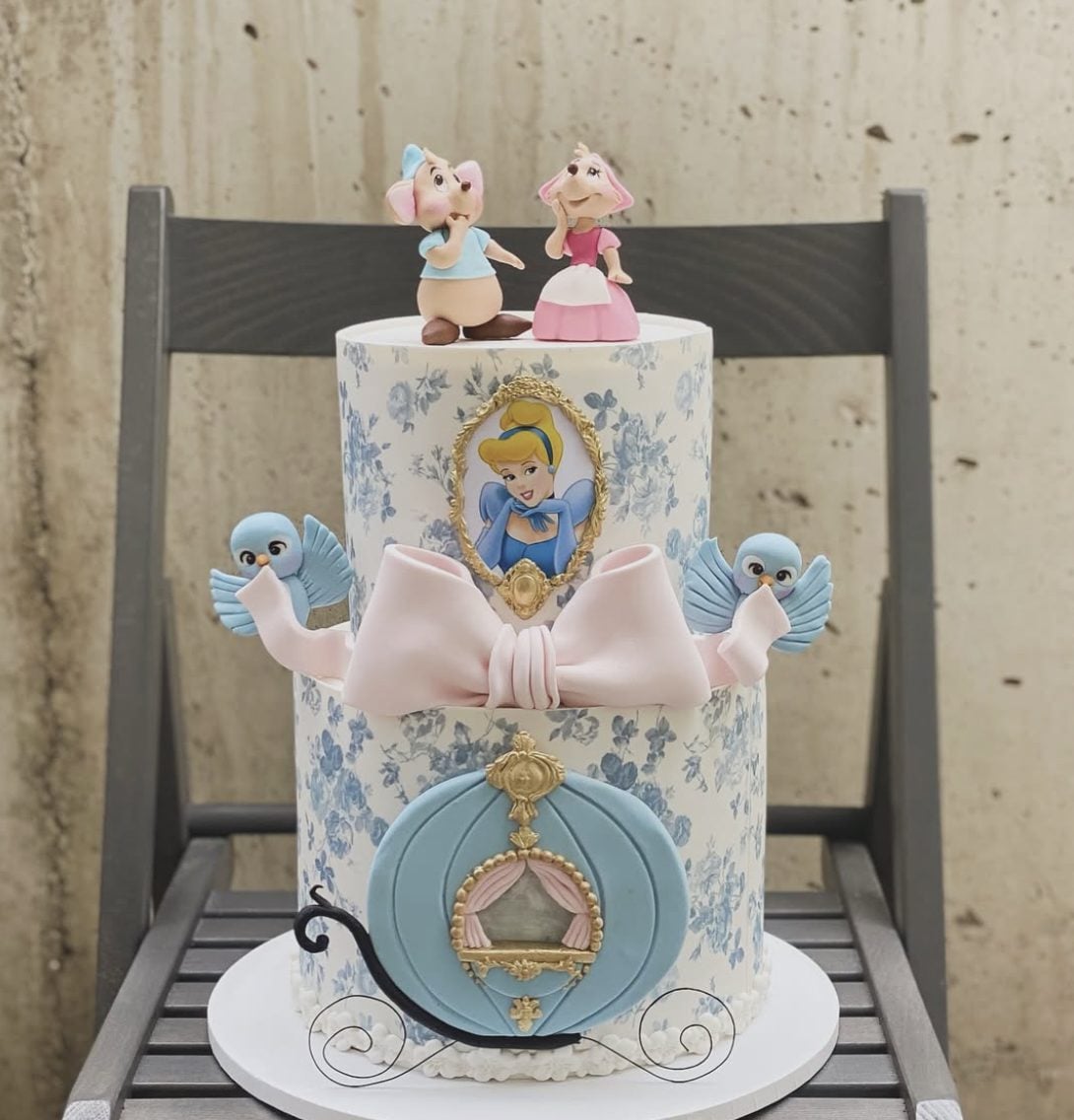 This Cinderella birthday cake is full of sweet storybook details. The blue floral pattern, soft pink bow, Cinderella portrait, little blue birds, and Jaq and Gus toppers make it feel delicate, playful, and perfect for a princess party.