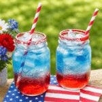 Red, white, and blue patriotic punch in glasses with red sugar rims, perfect for a summer holiday party.