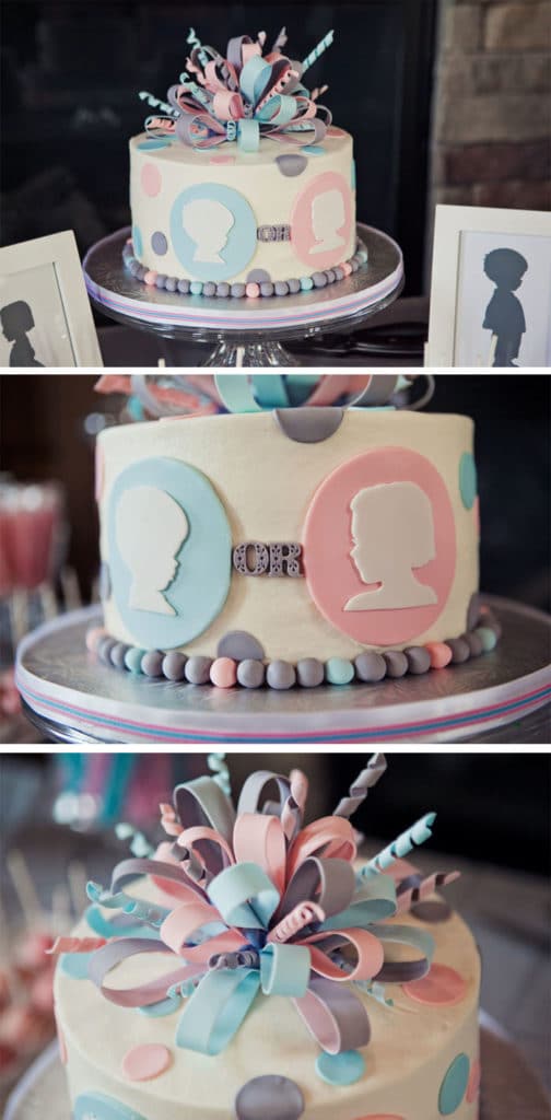A gender reveal party cake in pastel colours with ribbons and confetti on top. 
