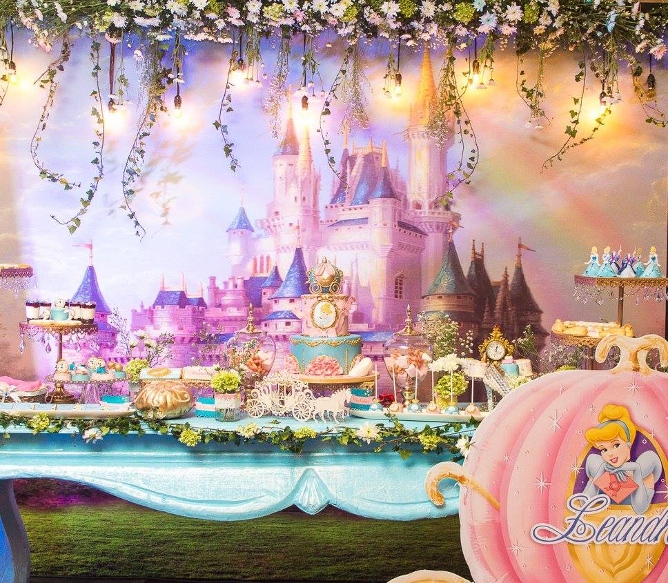 Amazing Cinderella party dessert table with princess castle backdrop and themed cake and desserts.