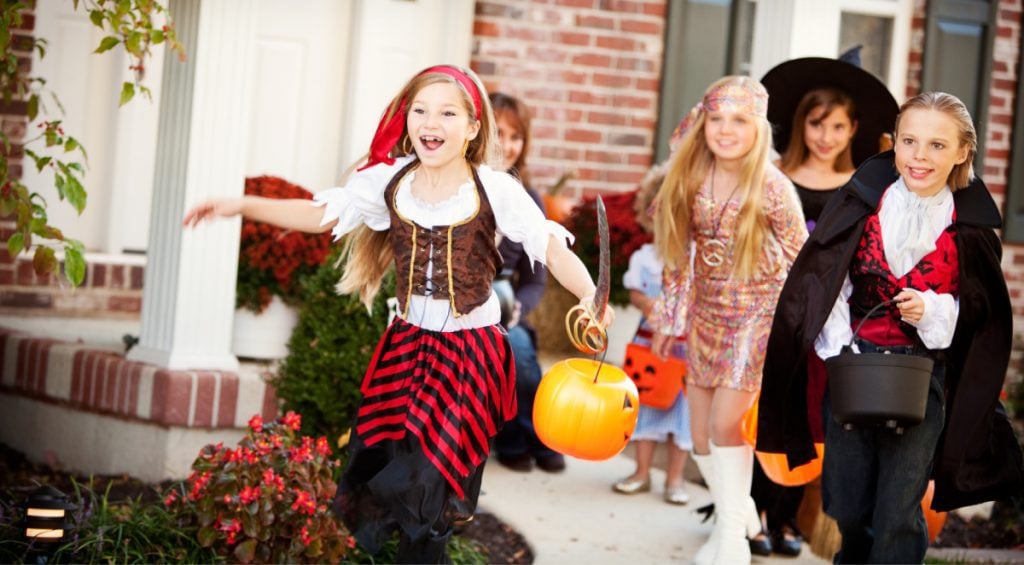 Kids in costumes playing a Halloween scavenger hunt