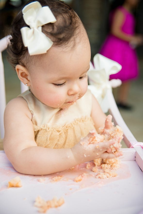 1st birthday girl eating her cake