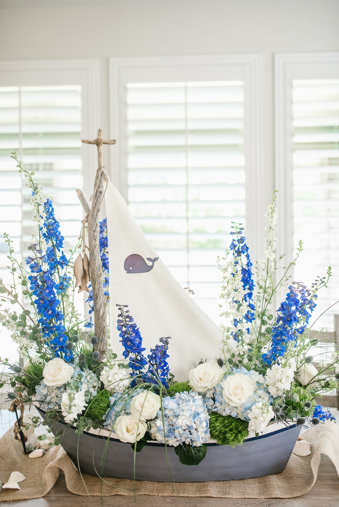 Whale boat baby boy blue and white flower arrangement for a baby shower