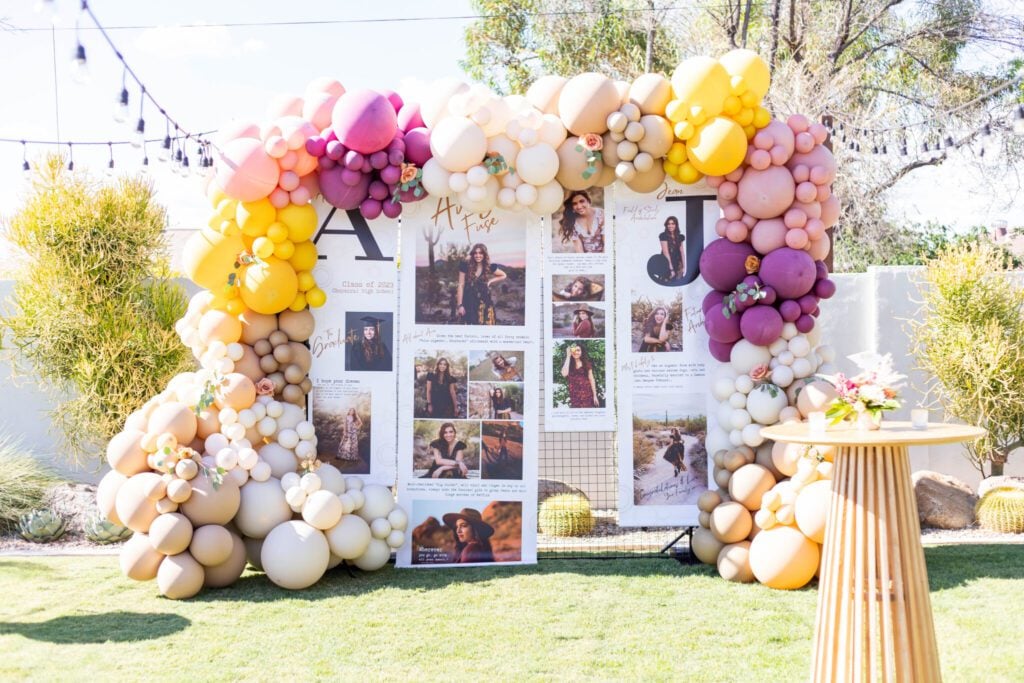 Graduation party photo display surrounded by colorful balloon garlands