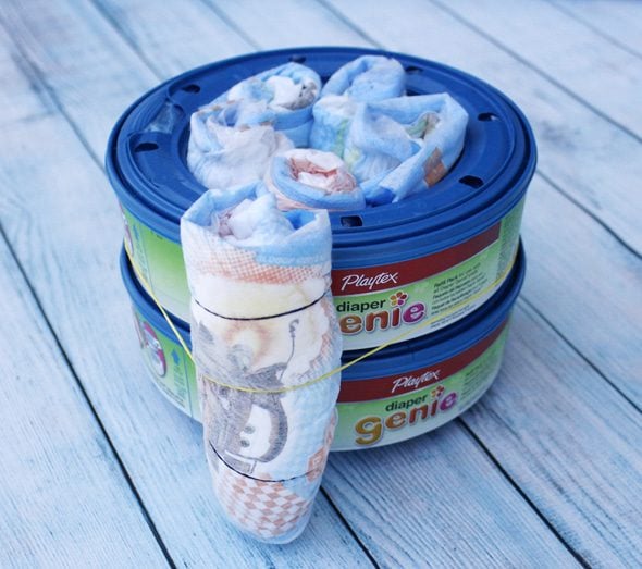 Diaper genie refill as based with rolled diaper attached to the outside to make a mini diaper cake