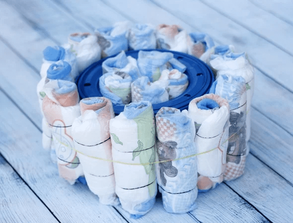 Rolled diapers tucked in and around the diaper genie refill
